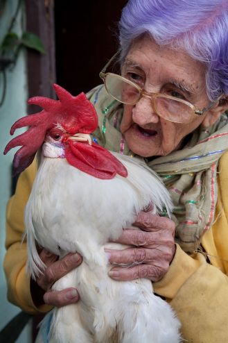 A 95 year old woman with her pet rooster. Havana (La Habana), Cuba